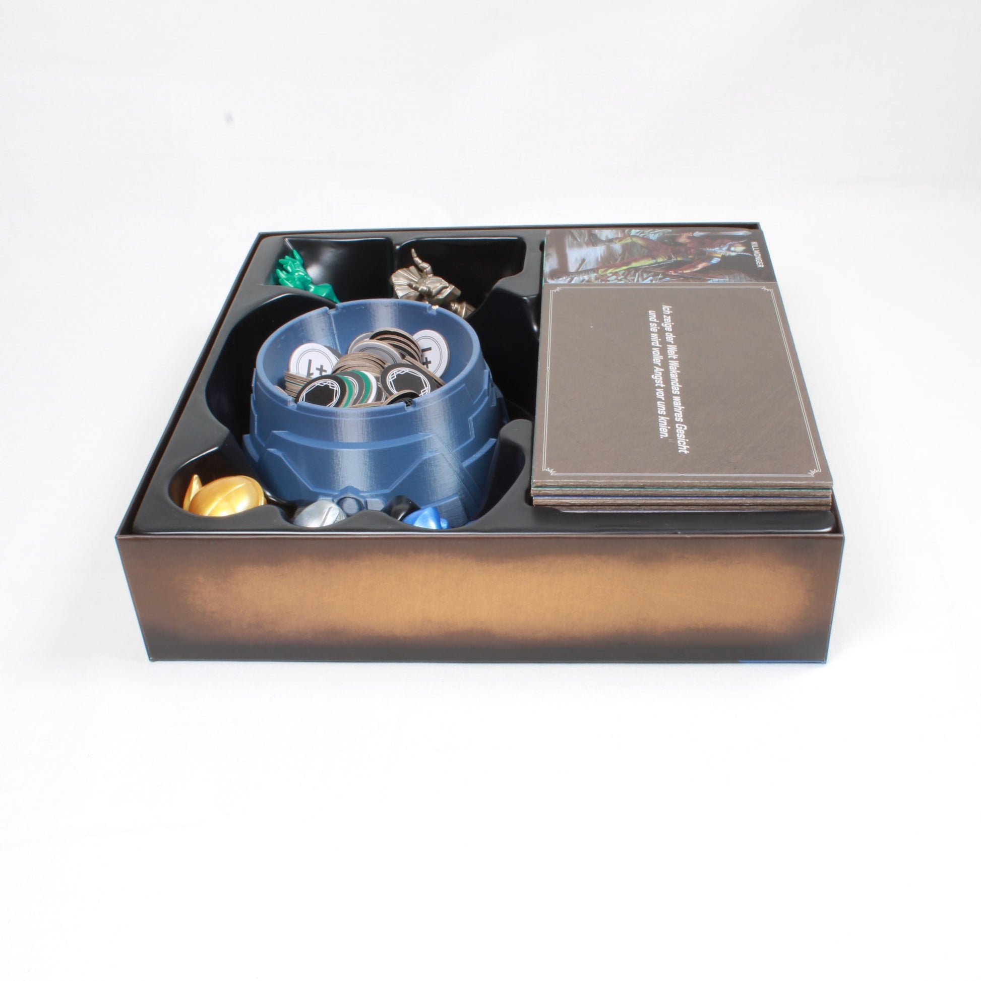Die Schale gefüllt mit den Token von Marvel Villainous in der Originalspielbox